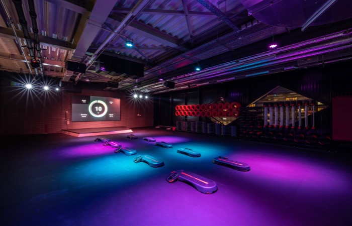Grupni fitnes studio sa energičnom atmosferom i muzikom tokom treninga